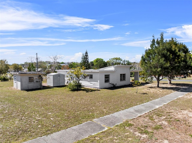 view of front of home featuring an outbuilding and a front yard