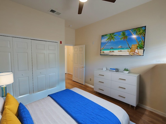 bedroom featuring wood finished floors, a ceiling fan, visible vents, baseboards, and a closet