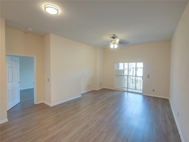 spare room featuring light wood-style flooring, visible vents, ceiling fan, and baseboards