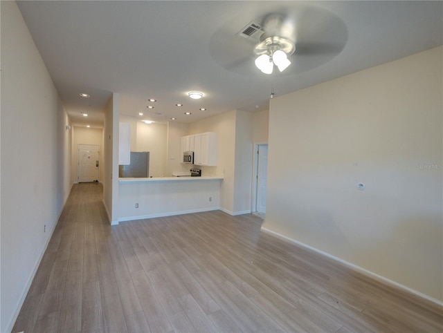 unfurnished living room with light wood-style floors, visible vents, and baseboards