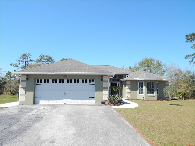 view of front facade with aphalt driveway, roof with shingles, stucco siding, a front yard, and a garage