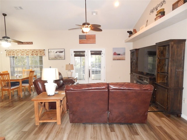 living room with a ceiling fan, a wealth of natural light, and light wood-style floors