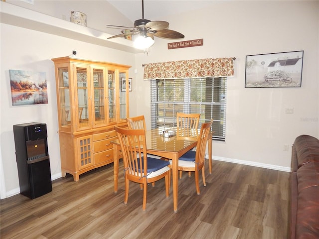 dining space with vaulted ceiling, wood finished floors, a ceiling fan, and baseboards