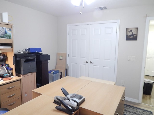 home office featuring wood finished floors, visible vents, and baseboards