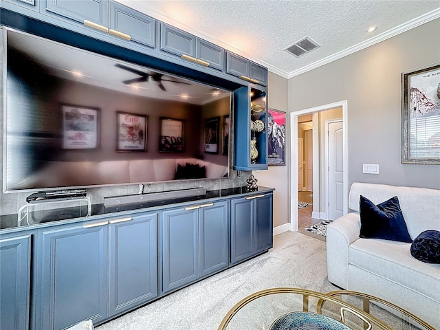 kitchen featuring light carpet, a textured ceiling, visible vents, and blue cabinets