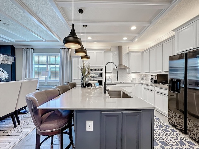 kitchen with a breakfast bar, black fridge with ice dispenser, ornamental molding, backsplash, and wall chimney exhaust hood