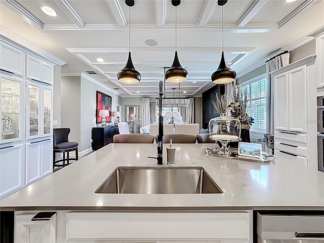 kitchen with white cabinetry, open floor plan, crown molding, and pendant lighting