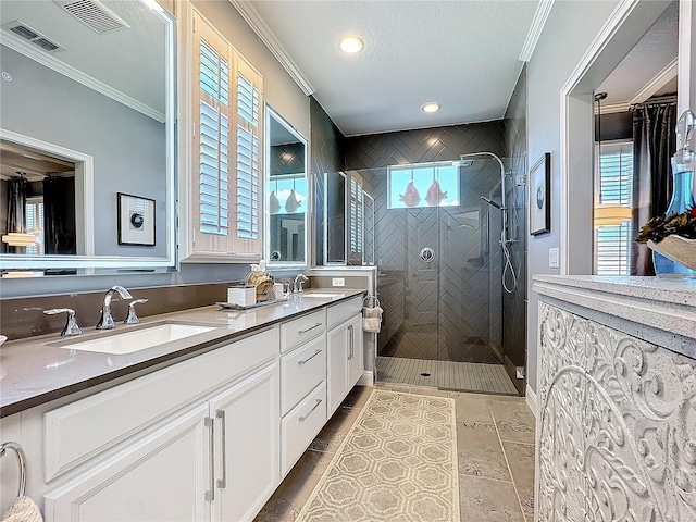 full bathroom with ornamental molding, a sink, and tiled shower