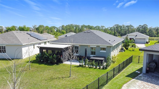 rear view of property featuring a yard, a fenced backyard, and stucco siding