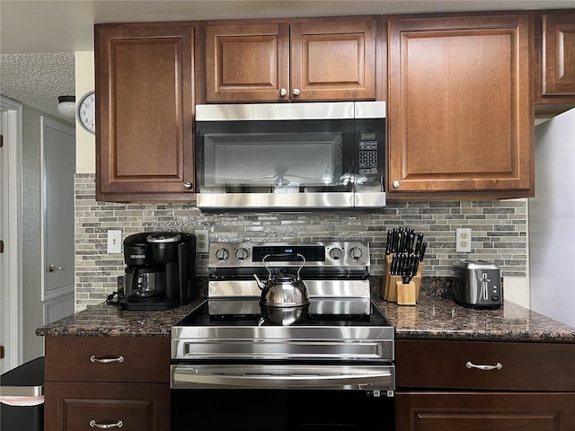 2494 Sweetwater Club Cir Unit 55, Kissimmee, FL 34746 - kitchen featuring appliances with stainless steel finishes, backsplash, and dark stone countertops