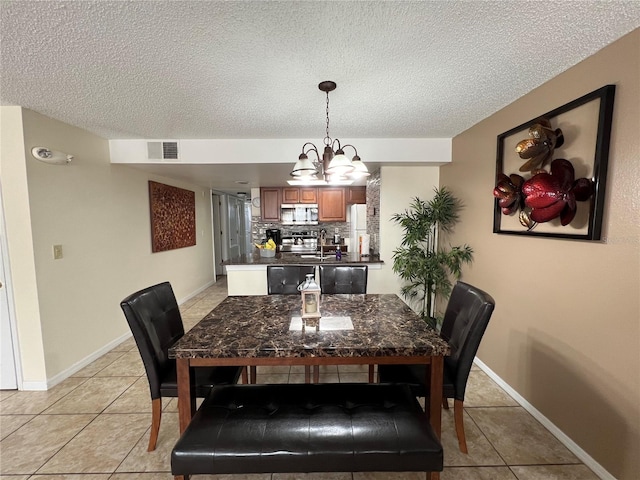 2494 Sweetwater Club Cir Unit 55, Kissimmee, FL 34746 - dining area with light tile patterned floors, visible vents, a textured ceiling, a chandelier, and baseboards