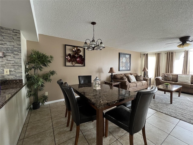 2494 Sweetwater Club Cir Unit 55, Kissimmee, FL 34746 - dining room with light tile patterned flooring, a textured ceiling, baseboards, and ceiling fan with notable chandelier