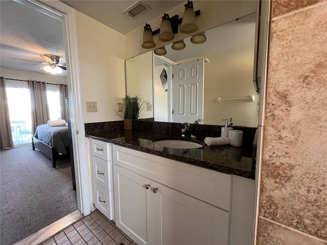 2494 Sweetwater Club Cir Unit 55, Kissimmee, FL 34746 - ensuite bathroom with visible vents, ceiling fan, vanity, ensuite bath, and a textured ceiling