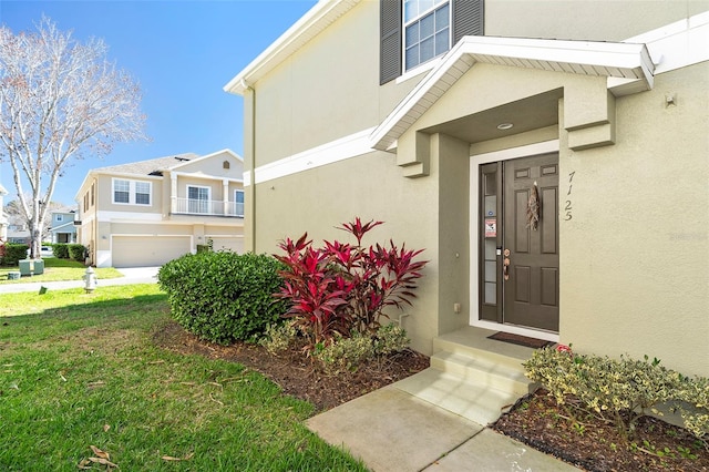 doorway to property featuring a residential view, a yard, and stucco siding