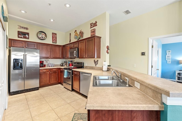 kitchen with visible vents, appliances with stainless steel finishes, a peninsula, light countertops, and a sink