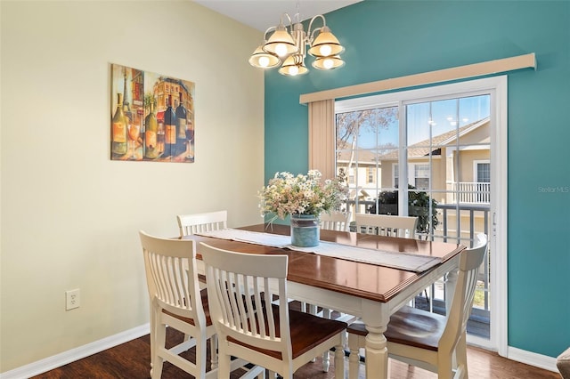 dining room with a chandelier, wood finished floors, and baseboards