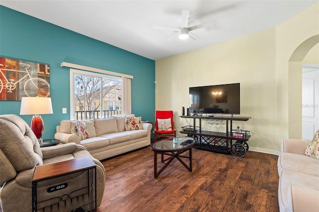 living room with a ceiling fan, arched walkways, baseboards, and wood finished floors