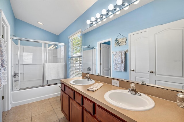 bathroom with lofted ceiling, tile patterned flooring, enclosed tub / shower combo, and a sink