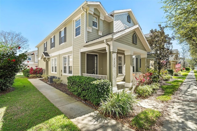 view of side of property with a porch, a lawn, and central AC unit