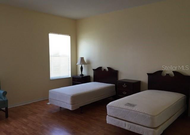 bedroom featuring baseboards and wood finished floors