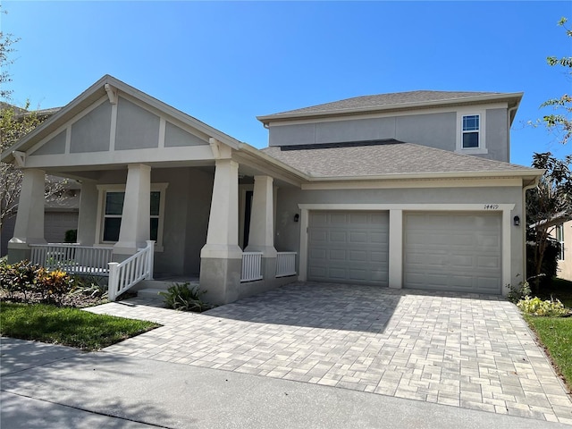 view of front of home with a garage, roof with shingles, decorative driveway, a porch, and stucco siding