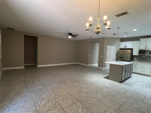 kitchen with light countertops, appliances with stainless steel finishes, a kitchen island, and visible vents