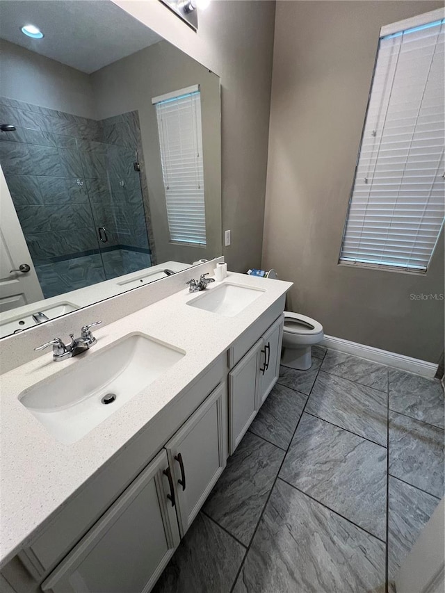 full bathroom featuring a stall shower, a sink, toilet, and double vanity