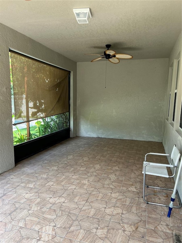 unfurnished sunroom with a ceiling fan