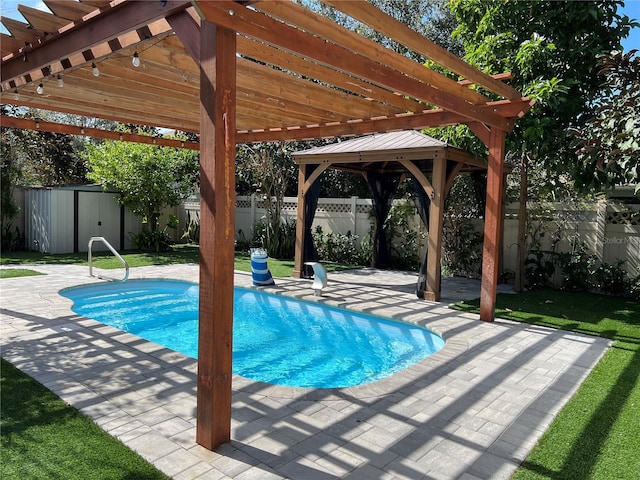 view of pool featuring a patio, a fenced backyard, an outdoor structure, a pergola, and a shed