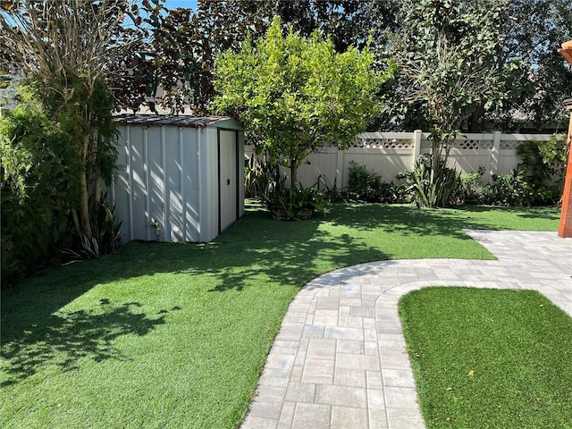 view of yard featuring an outdoor structure, fence, and a shed