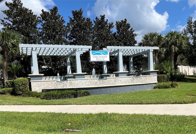 view of community featuring a pergola and a yard