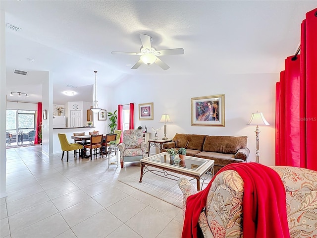 living area with a ceiling fan, visible vents, vaulted ceiling, and light tile patterned floors