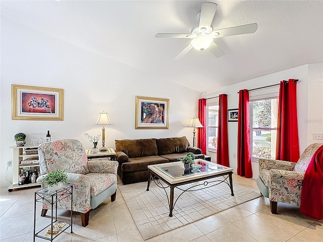 living room featuring a ceiling fan, vaulted ceiling, and light tile patterned floors