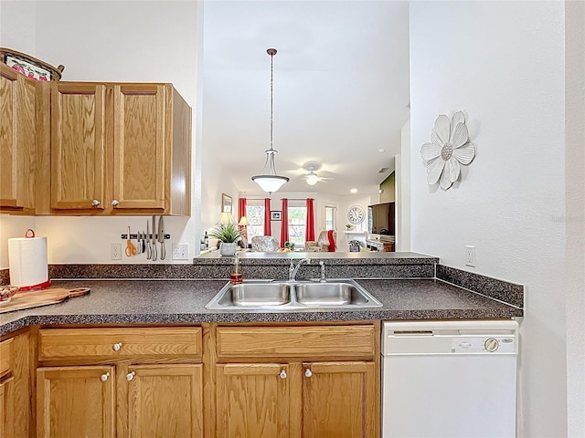 kitchen with a sink, dark countertops, dishwasher, and hanging light fixtures