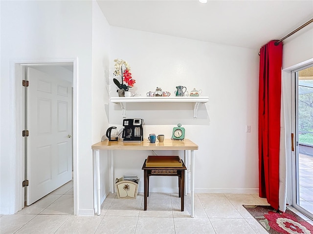 interior space featuring light tile patterned flooring and baseboards