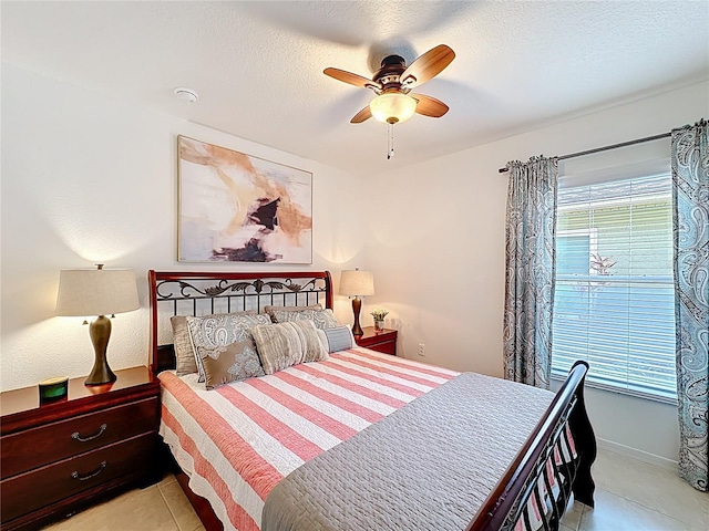 bedroom featuring a ceiling fan, multiple windows, a textured ceiling, and light tile patterned floors