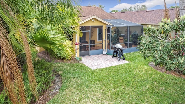 back of house with a shingled roof, a patio area, and a lawn