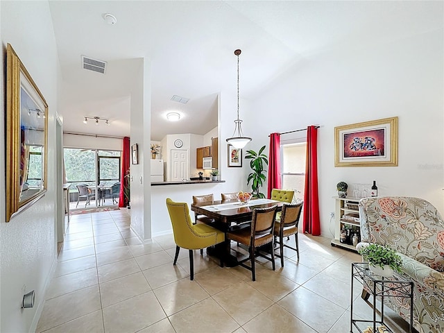 dining area featuring lofted ceiling, light tile patterned floors, baseboards, and visible vents