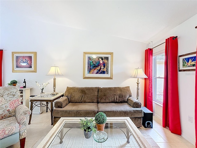 tiled living area with lofted ceiling and baseboards