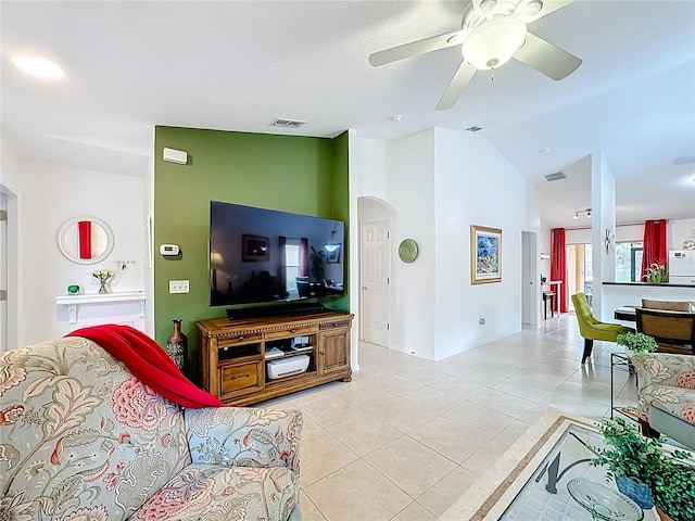 living area featuring visible vents, vaulted ceiling, arched walkways, and light tile patterned flooring