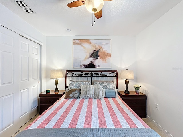 bedroom with baseboards, a textured ceiling, visible vents, and a ceiling fan