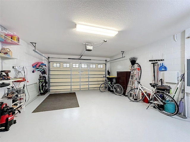 garage featuring concrete block wall and a garage door opener