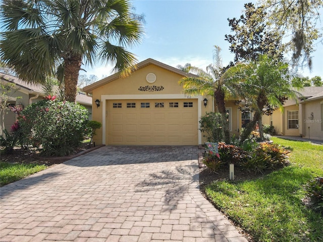 view of front facade featuring decorative driveway, an attached garage, and stucco siding