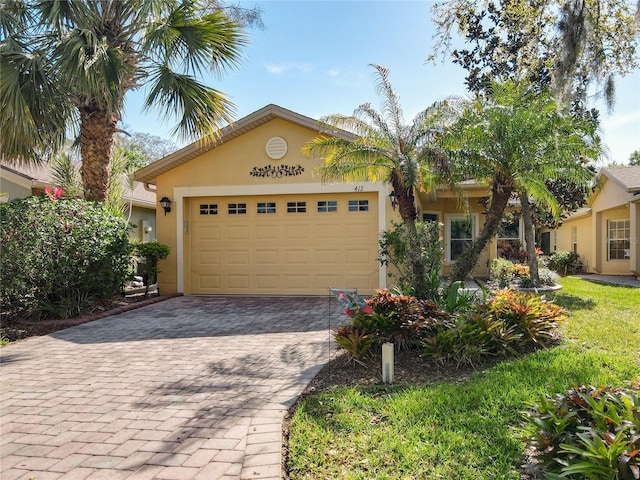 view of front of property featuring decorative driveway, a garage, and stucco siding