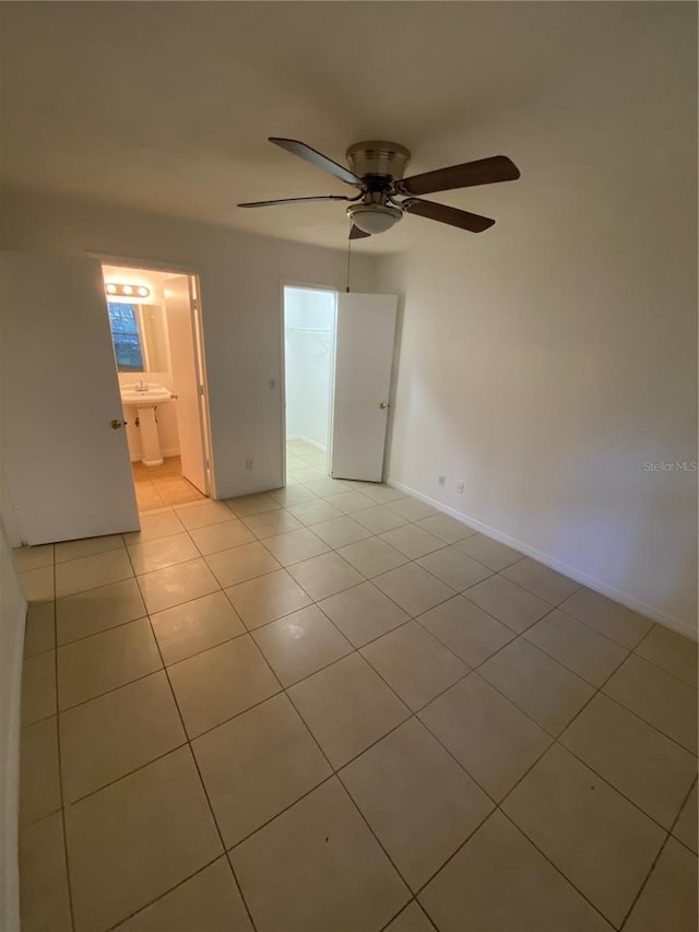 spare room with baseboards, a ceiling fan, and light tile patterned flooring