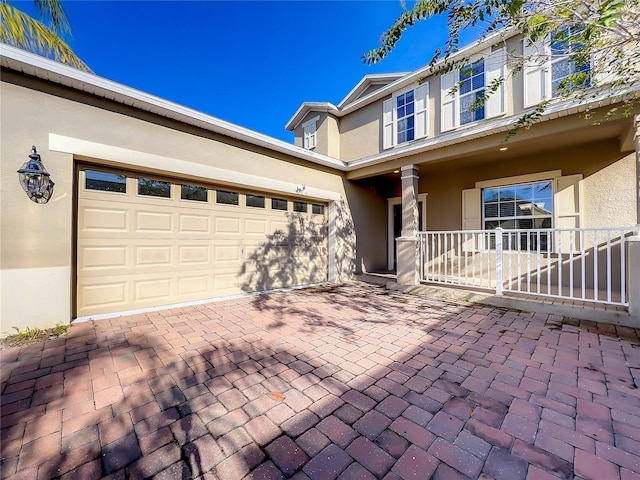 view of front of house with driveway, an attached garage, and stucco siding