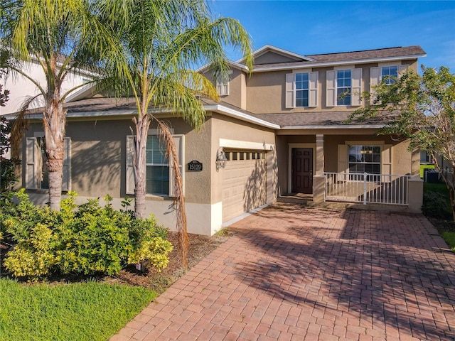 view of front of house with a porch, decorative driveway, a garage, and stucco siding