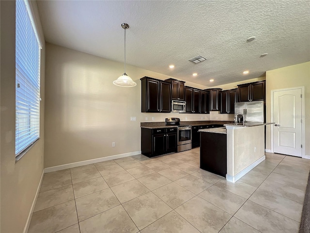 kitchen featuring light tile patterned floors, baseboards, visible vents, and stainless steel appliances