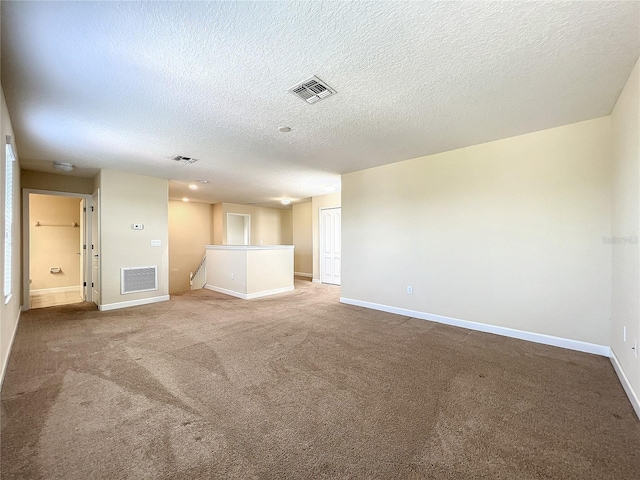 empty room with carpet floors, visible vents, and baseboards