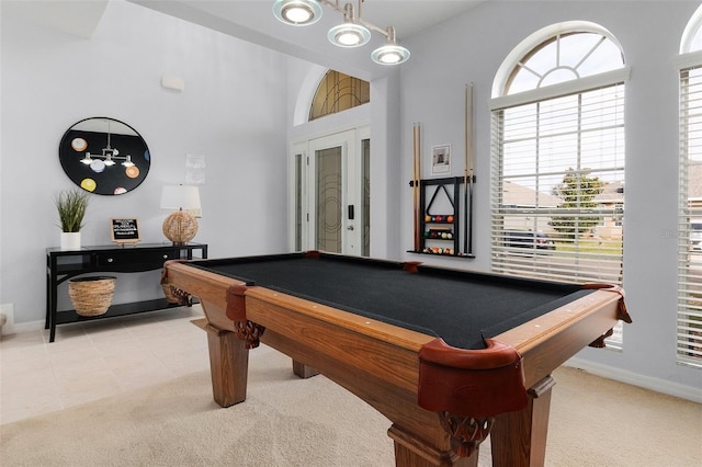 rec room with light tile patterned flooring, pool table, baseboards, light colored carpet, and a towering ceiling